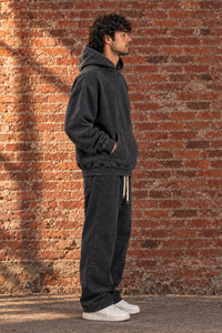 Black Snow Wash Fleece Oversize Hoodie, side view on model against brick wall