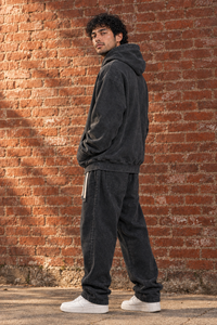 Black Snow Wash Fleece Oversize Hoodie, three-quarter view on model against brick wall